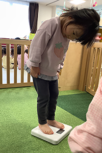 体重測定をする子ども