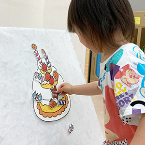 誕生日ケーキに飾り付けする子ども