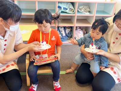 ケーキのろうそくの火を消す真似をする子ども