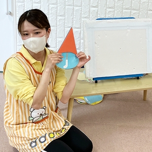 傘の絵の画用紙を見せる保育士