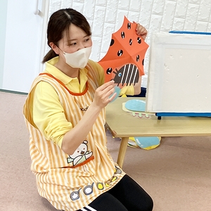 傘の絵の画用紙を開いて見せる保育士