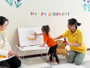 誕生日ケーキに飾り付けをする子ども