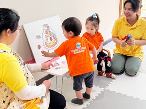誕生日ケーキに飾り付けをする子ども