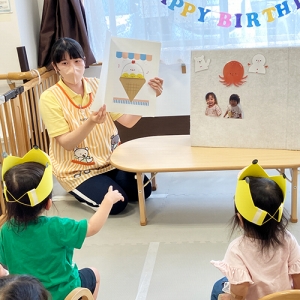 誕生日会で先生の出し物を楽しむ子どもたち