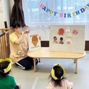 誕生日会で先生の出し物を楽しむ子どもたち