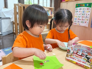 折り紙に好きなシールを貼る子どもたち
