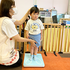 背筋を伸ばして身長を計ってもらう子ども