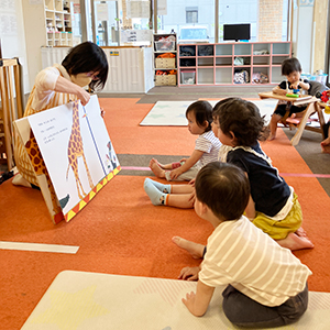 大型絵本の読み聞かせに夢中で身を乗り出す子どもたち