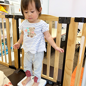 恐る恐る体重計に乗る子ども