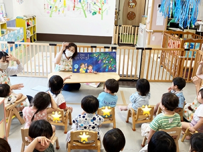 七夕会で絵本の読み聞かせを聞く子どもたち