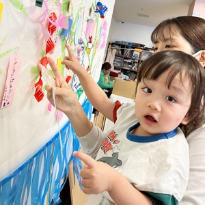 笹の葉に短冊をつける子どもたち