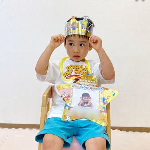 王冠をかぶってみんなの前に座る子ども