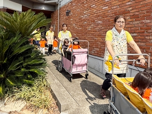 子どもたちが乗る避難車を押す保育士たち