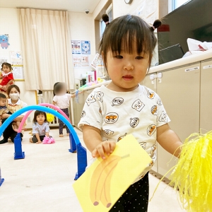 障害物リレーでバナナのカードを持つ子ども