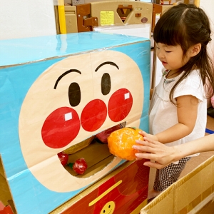 アンパンマンの口にボールを入れる子ども