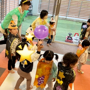 ハロウィーンの仮装をして風船遊びをする子どもたち