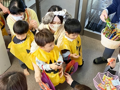 みんなで並んでハロウィーンのお菓子をもらいに行く子どもたち