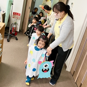 みんなで並んでハロウィーンのお菓子をもらいに行く子どもたち