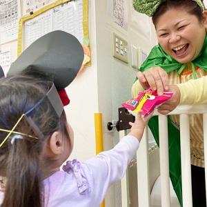 子どもにお菓子を手渡す職員