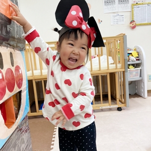 アンパンマンの顔の箱にキャンディーを入れて笑顔を見せる子ども