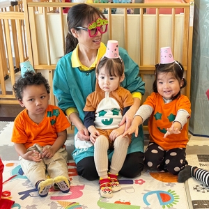 頭に紙コップの帽子を乗せて先生と写真撮影