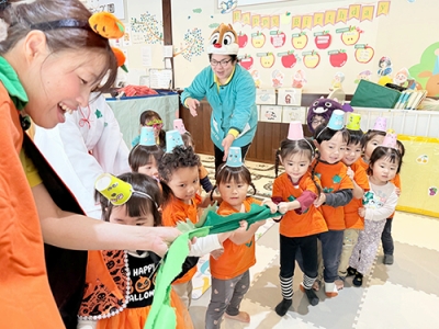 大きなかぼちゃをみんなで引っ張る子どもたち