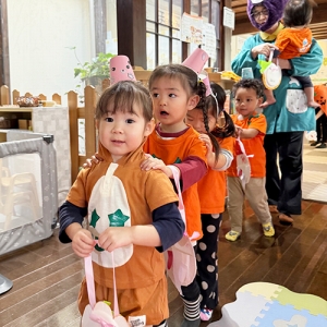 ハロウィーンの仮装をして列になってお菓子をもらいに行く子どもたち