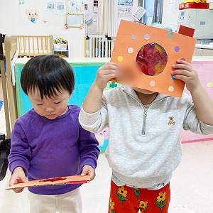 カラーセロハンを貼ったカメラを覗く子ども