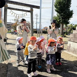 神社で手を合わせる子どもたちと先生