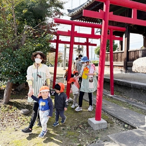 神社の鳥居の下を歩く子どもたち