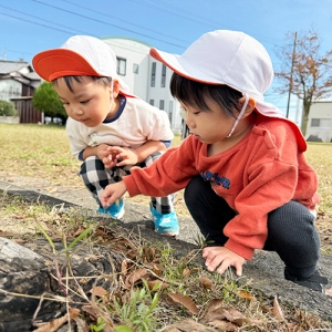地面で何かをみつけた子どもたち