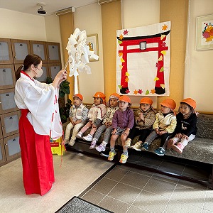 巫女さんに扮した保育士に祈祷を受ける子どもたち