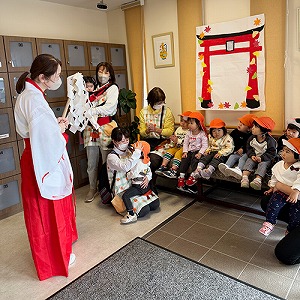 巫女さんに扮した保育士に祈祷を受ける子どもたち