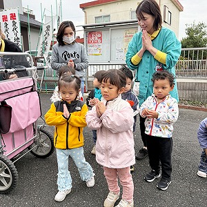 神社で手を合わせる子どもたちと保育士