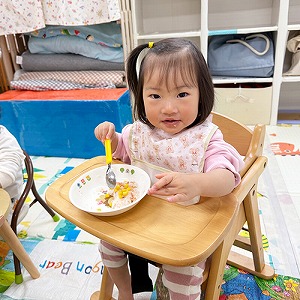 スプーンを持って給食を食べる子ども