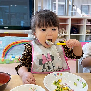 スプーンで給食を食べる子ども