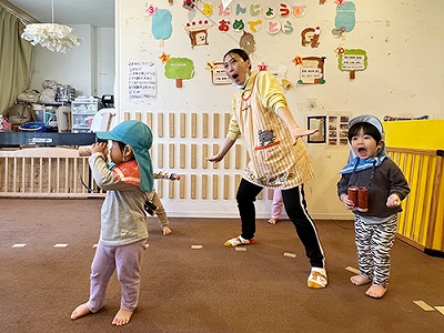 「ベイビーシャーク」の曲に合わせて準備体操をする園児と先生