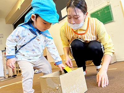 色玉を器で運び、同じ色の箱へ入れる子ども