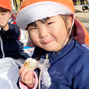 おにぎりを頬張る子ども