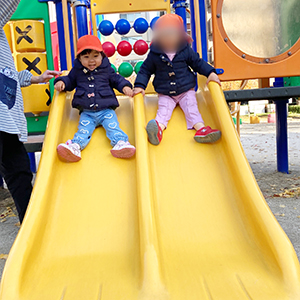 お友だちと一緒に滑り台をすべる子どもたち