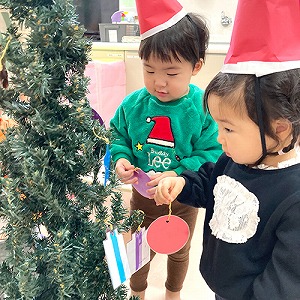 クリスマスツリーに飾り付けをする子どもたち
