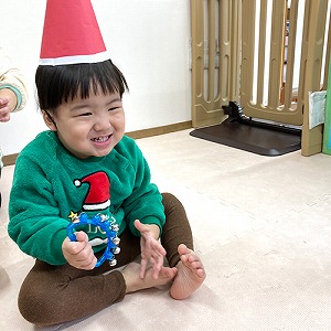 手に鈴を持って笑う子ども