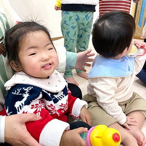 手に鈴を持って笑う子ども