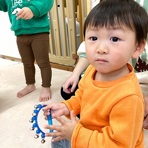 手に鈴を持って笑う子ども