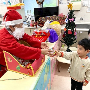 サンタクロースからプレゼントを受け取る子ども
