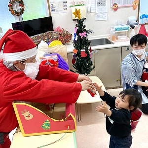 サンタクロースからプレゼントを受け取る子ども