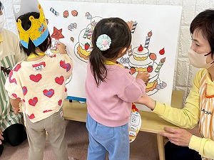 誕生日ケーキをデコレーションする子どもたち