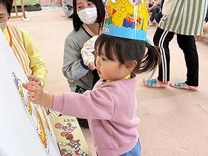 誕生日ケーキをデコレーションする子ども