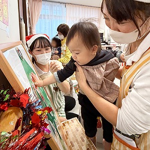 オーナメントをツリーに飾る子ども