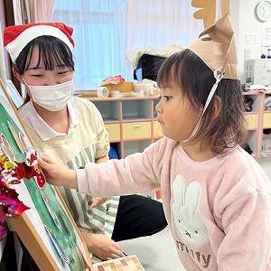 オーナメントをツリーに飾る子ども